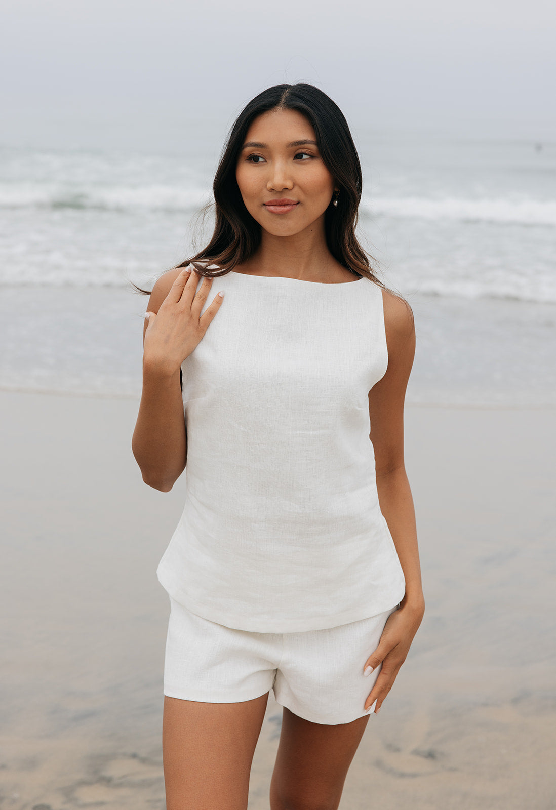 Woman in a white outfit standing on a beach