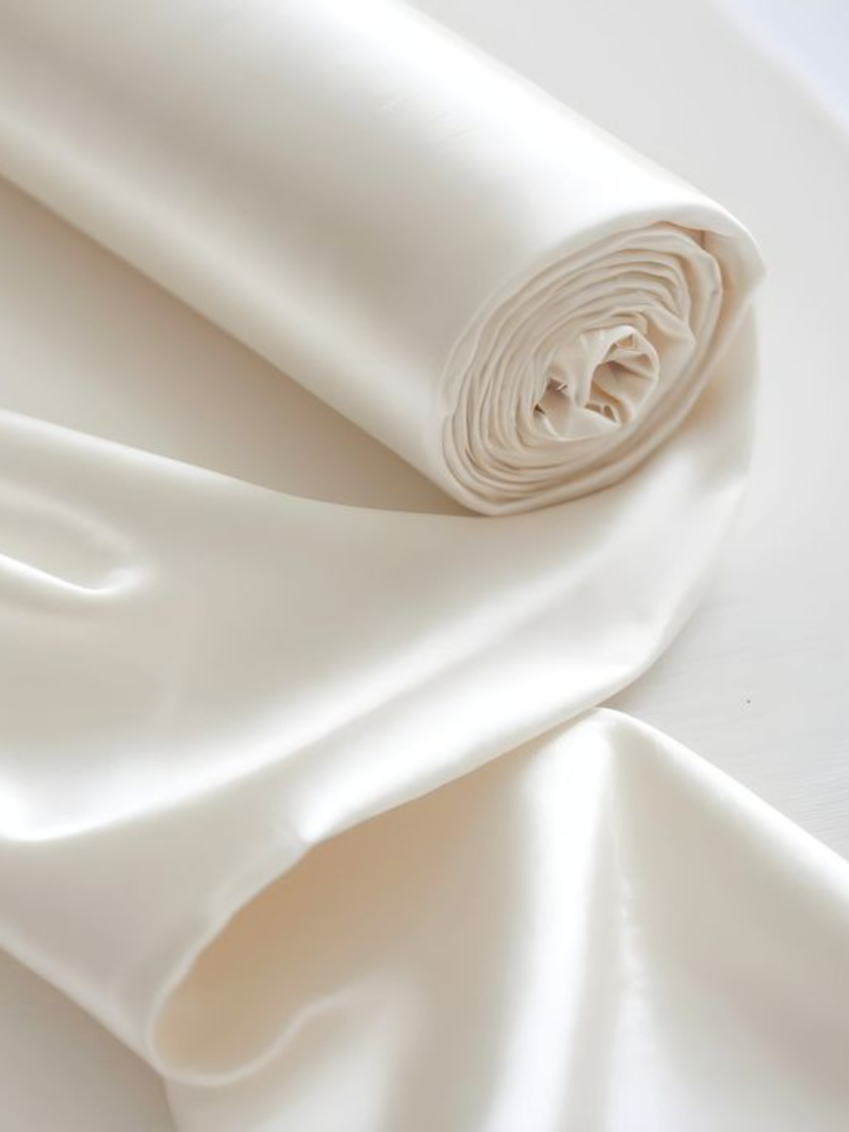 Close-up of white fabric with a roll on a light background