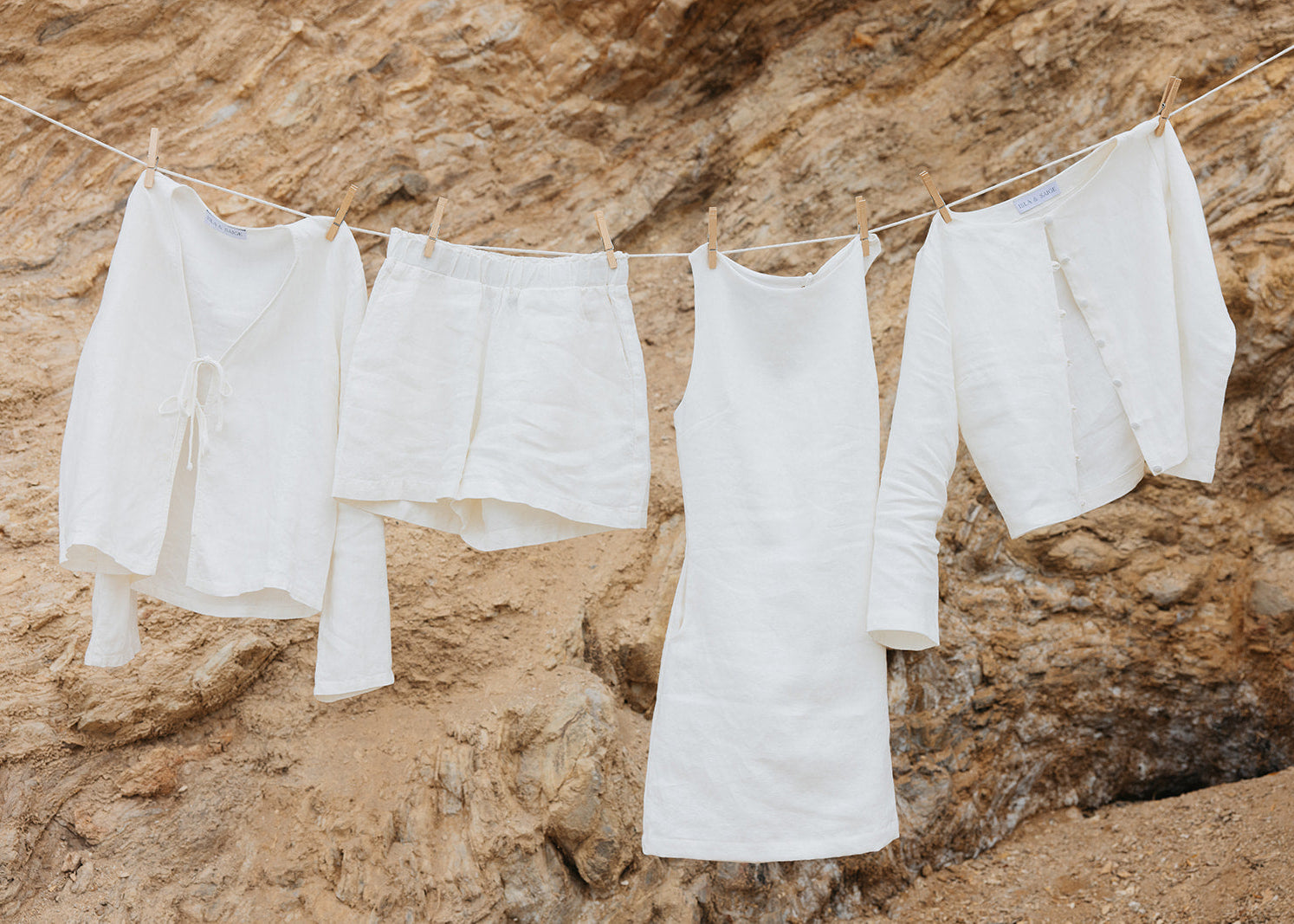 White clothing hanging on a clothesline against a rocky background